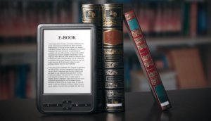 Alte Bücher und ein e-book stehen aufgestellt auf einem Tisch