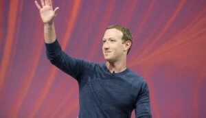 facebook chef markt zuckerberg winkt auf rotem hintergrund