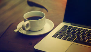 eine tasse kaffe steht auf einem tisch neben einem laptop als symbol für news im bereich bitcoin