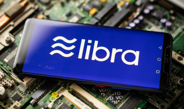 Facebook-Coin: Calibra-Wallet bekommt neuen Namen das libra-symbol auf einem smartphone, das auf einem elektronischen technologie-hintergrund liegt