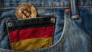 Bitcoin-Münze in schwarz-rot-gold-gefärbter Uhrentasche einer Jeans