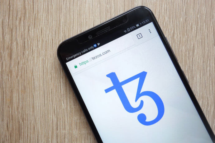 Das Logo von Tezos auf einem Smartphone abgebildet