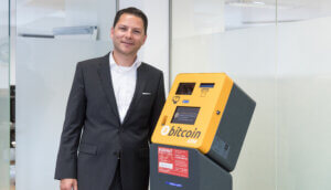 Der Geschäftsführer der Kurant steht an einem Bitcoin-Automaten