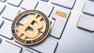 Bitcoin Münze auf Tastertur mit HODL Schriftzug
