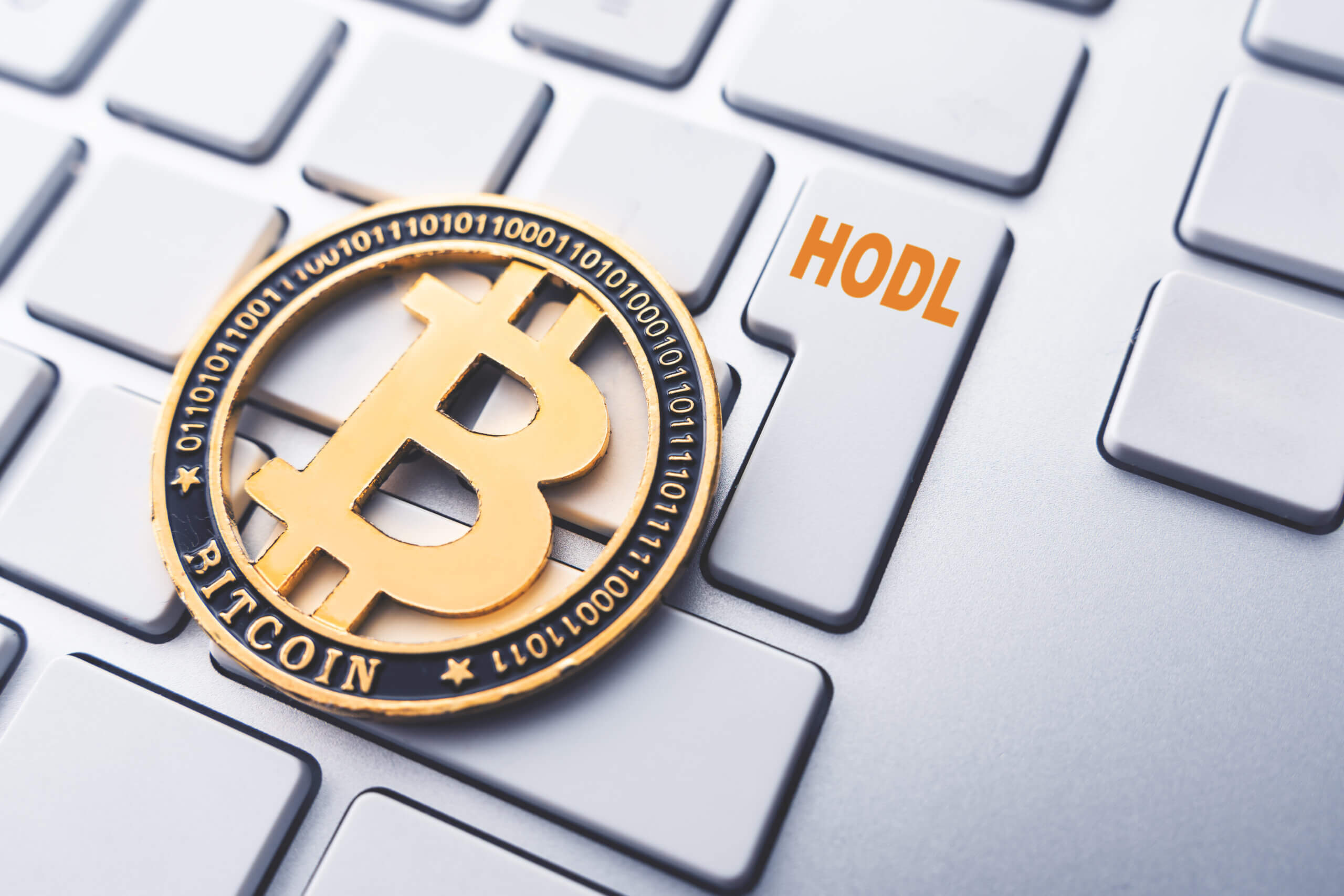 Bitcoin Münze auf Tastertur mit HODL Schriftzug