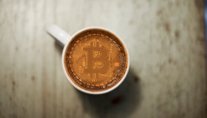 eine bitcoin-münze in einer kaffetasse