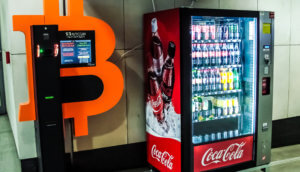 Ein Bitcoin-Automat steht neben einem Coca-Cola-Automat