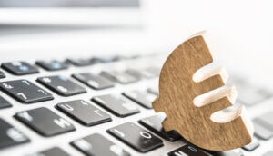 ein hölzernes euro symbol, das auf einer tastatur liegt