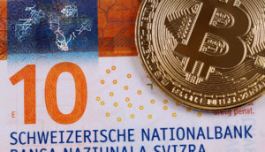 Bitcoin-Münze auf Zehn-Franken-Note