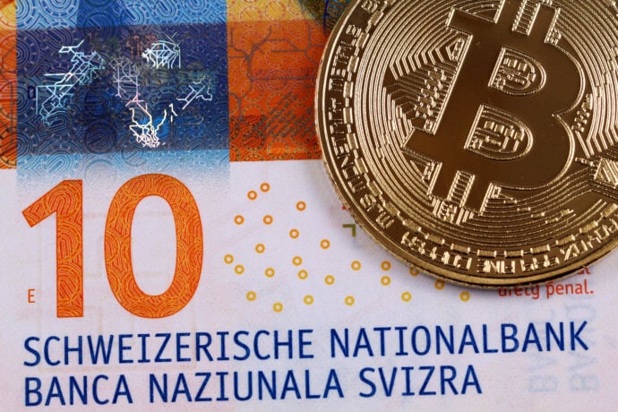 Bitcoin-Münze auf Zehn-Franken-Note