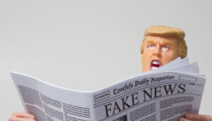 Spielfigur mit Ähnlichkeit zu Donald Trump mit einer Ausgabe des fiktiven „Covefefe Daily Reporter“