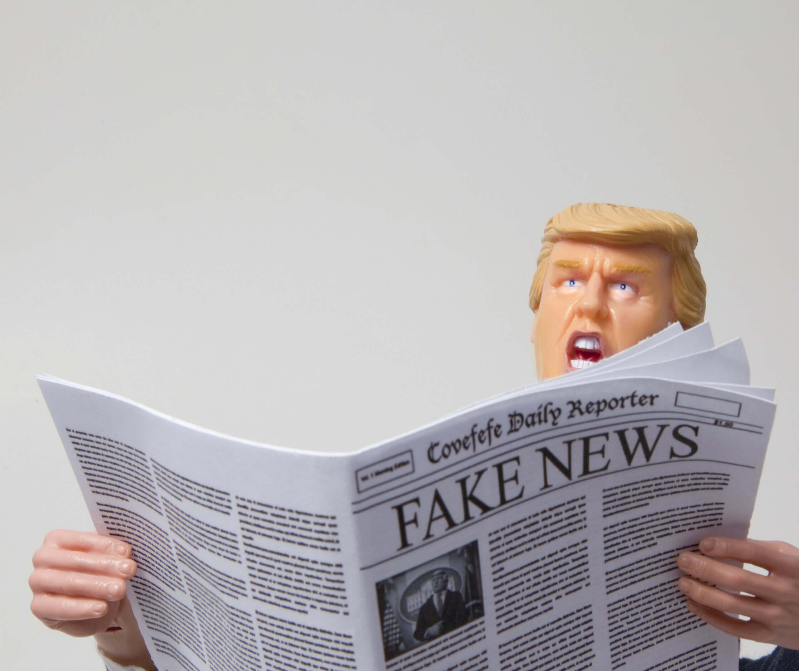 Spielfigur mit Ähnlichkeit zu Donald Trump mit einer Ausgabe des fiktiven „Covefefe Daily Reporter“