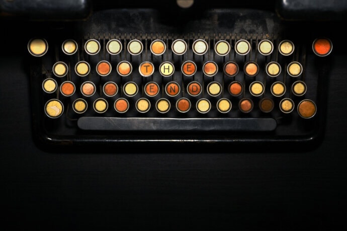 Eine Schreibmaschine, die die Buchstaben "the end" anzeigt mit gelben und roten tasten auf schwarzem hintergrund