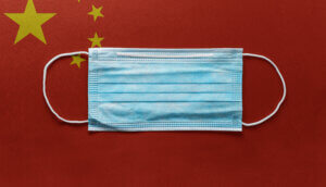 Chinesische Flagge mit Mundnasenschutz