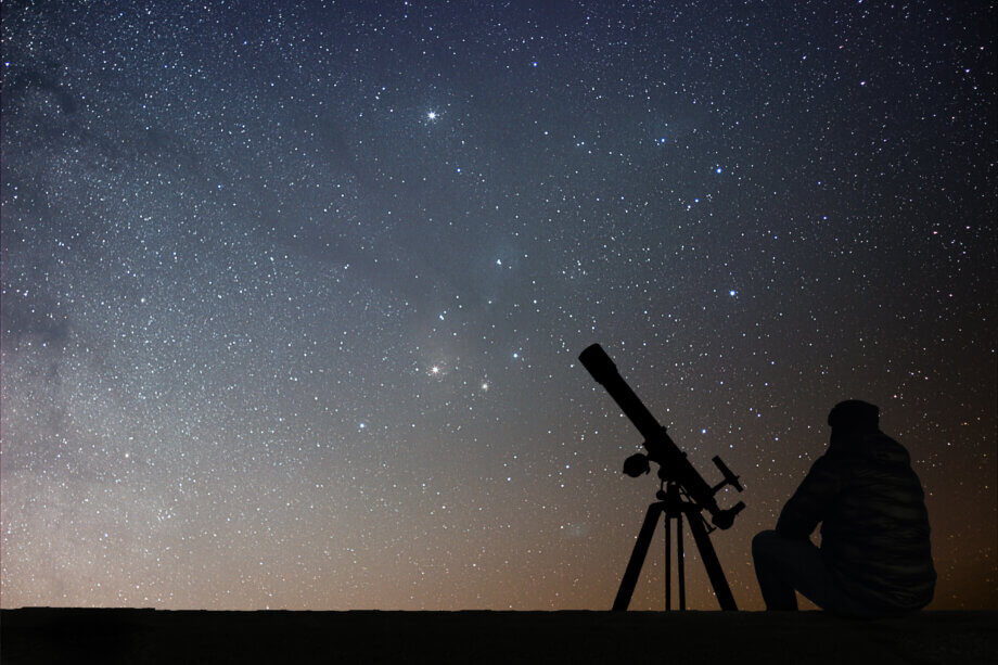 Compound (COMP): Neuer Stern am DeFi-Himmel? ein mann der vor einem teleskop sitzt und damit in die sterne schaut