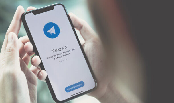 Telegram muss 18,5 Millionen US-Dollar Strafe zahlen die telegram app auf einem smartphone, das von zwei händen gehalten wird