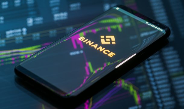 Bitcoin-Börse Binance kommt nach Deutschland smartphone-mit-binance-logo-liegt-auf-einem-glastisch