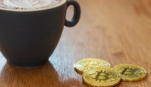 ein toller kaffeebecher und ein paar bitcoin münzen