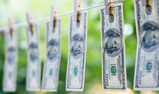 Bittere Pillen: Spanische Polizei geht gegen Krypto-Geldwäscher vor mehrere dollarscheine, die an einer leine zum trocknen hängen