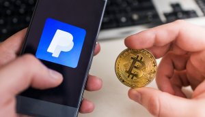 Smartphone mit PayPal-Logo, daneben eine Bitcoin-Münze