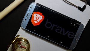 Smartphone auf Klemmbrett mit Kompass, das Display ziert das Logo des Brave Browser