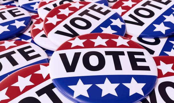 Wahljahr 2020: Krypto-Unternehmer Brock Pierce kandidiert für US-Wahlen 3D-Darstellung von Haufen amerikanischer Wahlknöpfe mit US-Flaggenfarben