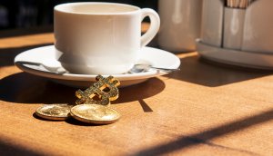 Kaffeetasse und Bitcoin-Münze