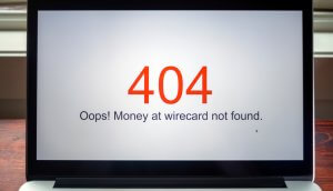 ein laptop, der die roten zahlen 404 zeigt und darunter in schwarzer schrift "oops" money at wirecard not found"