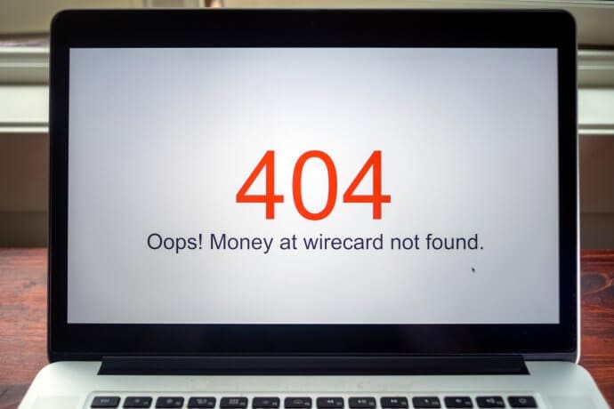 ein laptop, der die roten zahlen 404 zeigt und darunter in schwarzer schrift "oops" money at wirecard not found"