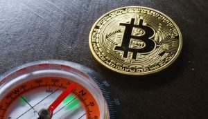 Bitcoin-Münze neben einem Kompass