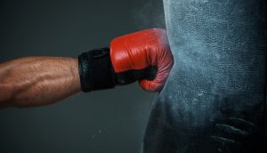 Mensch schlägt auf Boxsack ein