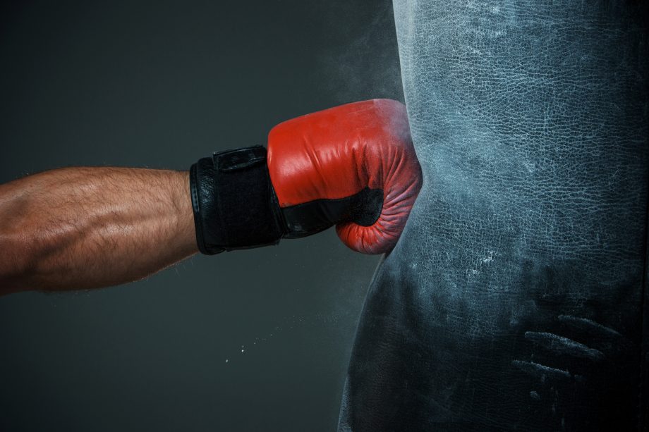 Bitcoin-Börse Binance gelingt Schlag gegen Geldwäsche Mensch schlägt auf Boxsack ein