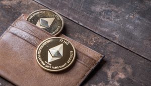 Ethereum Münzen liegen in einer Briefbörse auf einem Holztisch