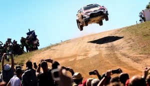 Rennauto springt bei einer Rallye über einen Hügel