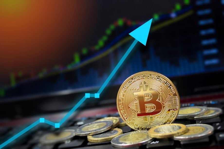 Bitcoin-Münze vor Börsenchart (Symbolbild Bitcoin-Kurs)