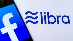 Facebook-Logo auf Smartphone vor Libra-Hintergrund