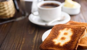 Breakfast with coffee and toasts. Toast with bitcoin symbol.