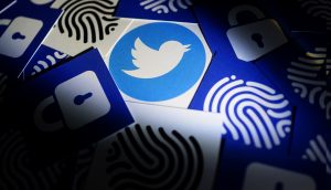 Twitter security and privacy issues. Hacker with computer hacking and stealing data information, Twitter logo and binary code as background.