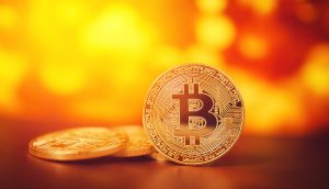 Bitcoin-Münze vor gelben Hintergrund.