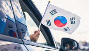 Südkorea-Flagge, die aus einem offenen Autofenster gehalten wird