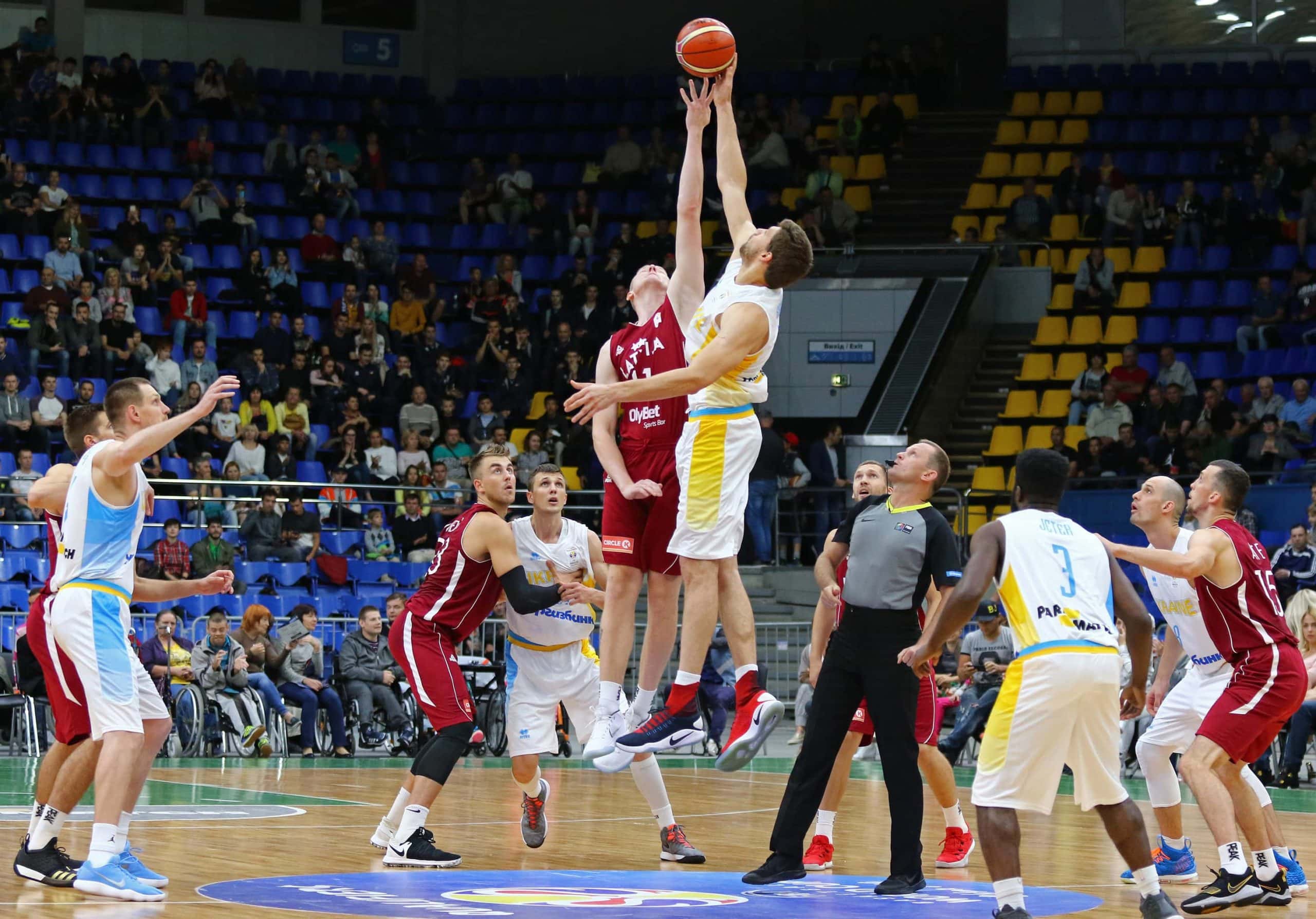 Basketballer versuchen, den Ball am Anfang des Spiels zu holen