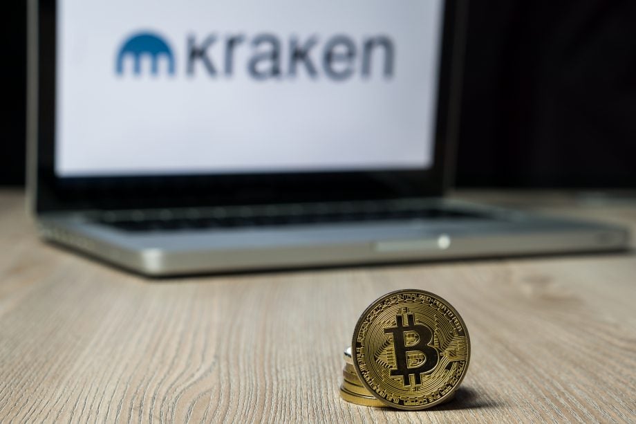 Bitcoin-Börse: Kraken streckt Arme nach klassischen Banken aus Bitcoin vor Laptop mit Kraken-Logo