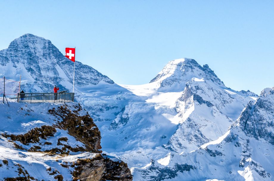Bitcoin Suisse: DOT, XTZ, DASH und ADA als Kreditsicherheit Schweizer Fahne vor Bergen