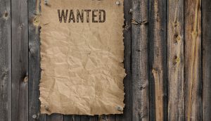 Wanted Schild an Holzzaun genagelt