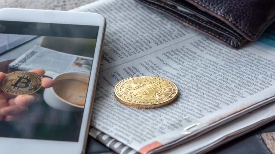 Die Top News der Woche: Zwischen Bitcoin ETF und Krypto-Kunstwerk Morning news cryptocurrency with newspaper and bitcoin on mobile screen.