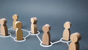 Eine Blockchain-Menschenkette aus Holzfigürchen.