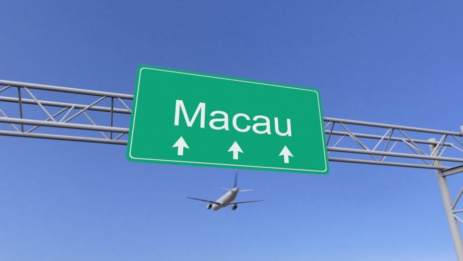Blockchain-Reisen: China setzt bei Grenzkontrollen auf DLT Flugzeug im Hintergrund, Macao-Schild im Vordergrund