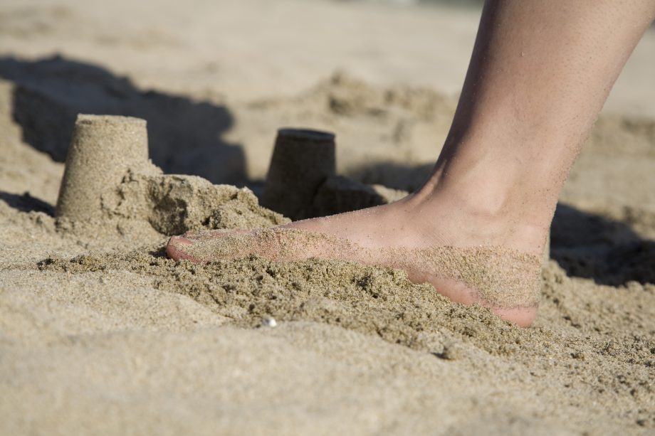 Abverkauf bei Ethereum, Iota und Ripple lässt Kursphantasien platzen Ein Fuß zertritt eine Sandburg