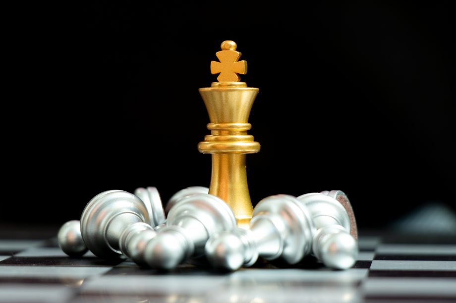 Mit cleveren CFD Investments das Beste aus der Krise machen Goldener Schach-König umringt von silbernen Bauern, die auf dem Brett liegen
