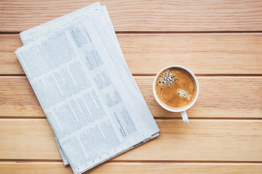 Bitcoin-Extrablatt: Top News der Woche zu digitalem Gold Eine Zeitung liegt zusammen mit einer Kaffeetasse auf einem Tisch.